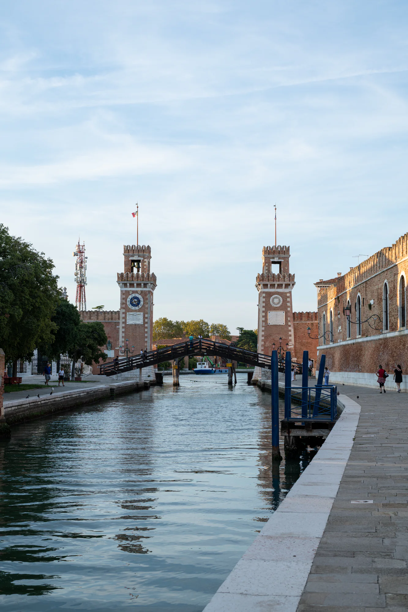 Canal, wooden bridge and twin brick towers at the water entrance of the Venetian Arsenal.